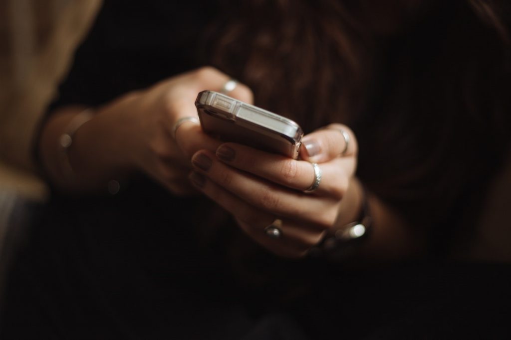 A close up of a woman's hands holding a cellphone