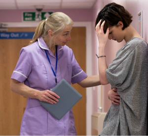 an older nurse comforts a distressed person